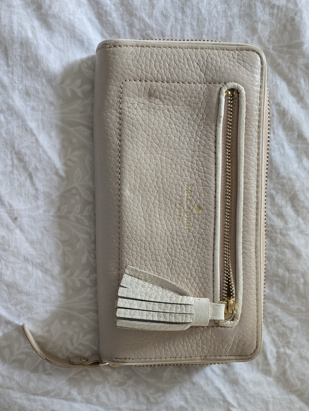 kate spade Pebbled Leather Zip Wallet in Light Taupe with White Tassel